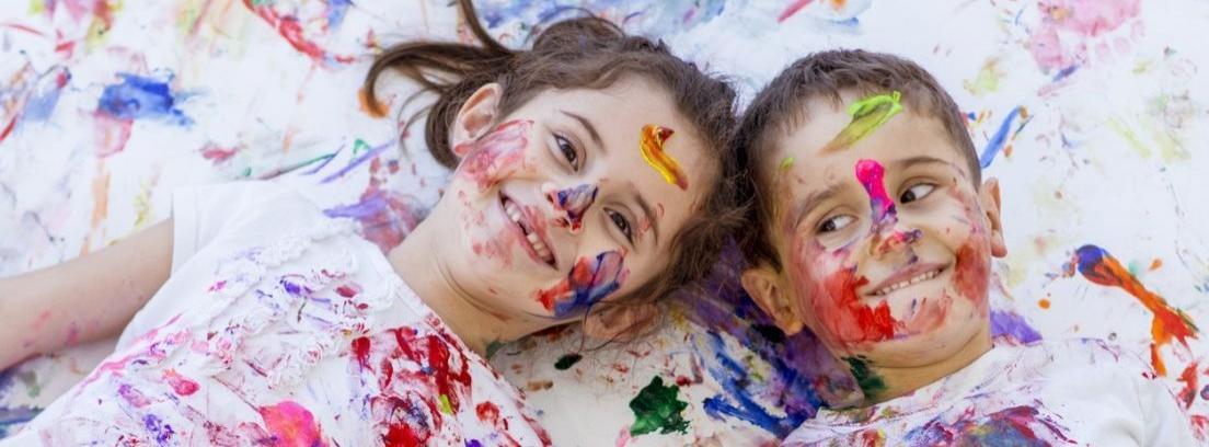 Un niño lleno riéndose lleno de pintura
