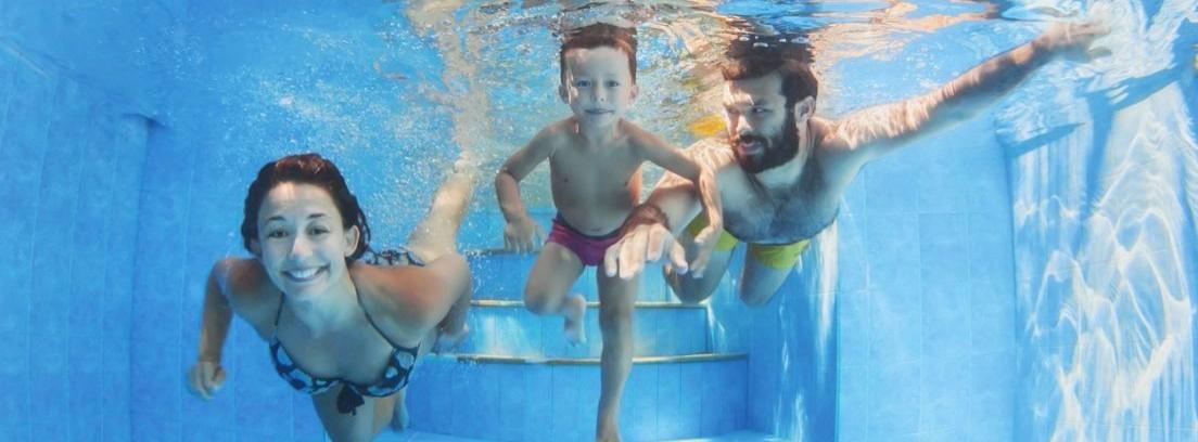 Padre practicando natación con sus dos hijos