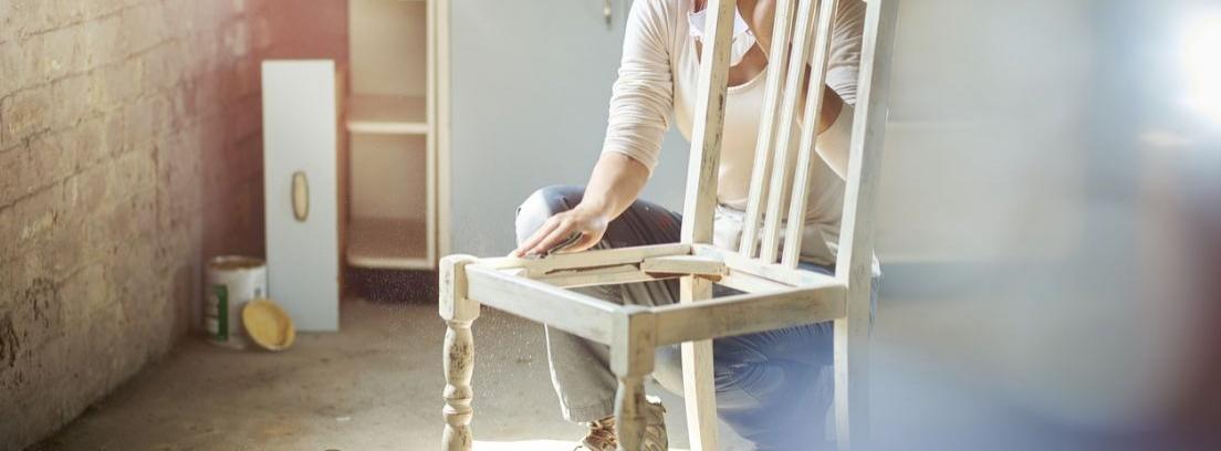 Hombre lijando una silla de madera