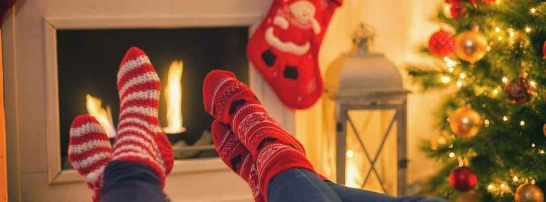 Cuatro calcetines navideños colgados de la repisa de la chimenea