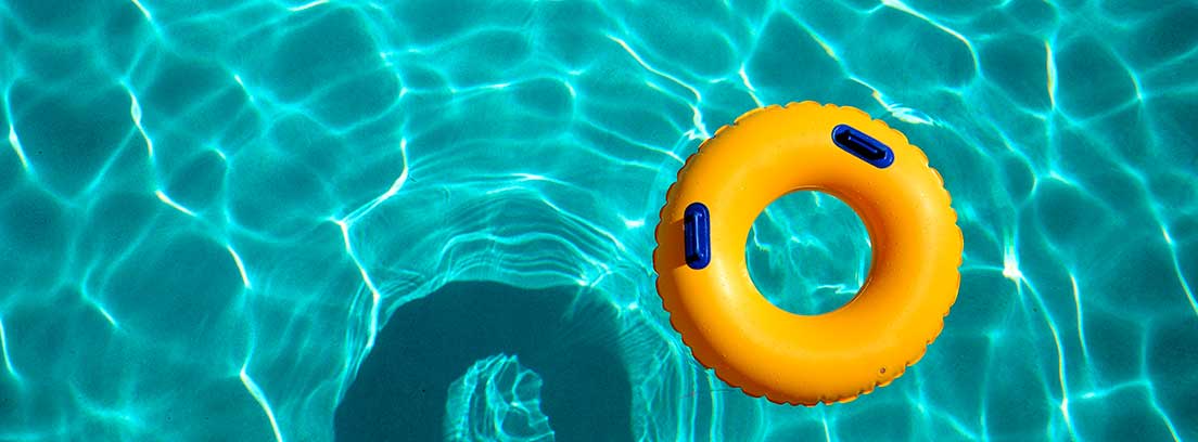 Un flotador amarillo y azul flota sobre el agua de una piscina