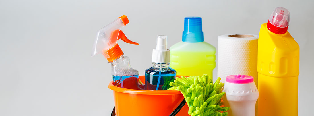 diferentes productos de limpieza con cepillo y mopa junto a un cubo de color naranja