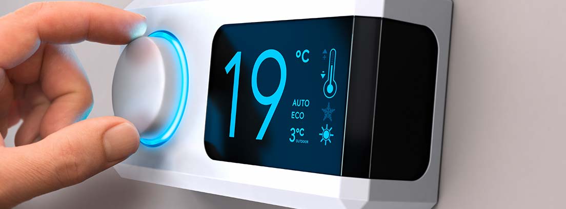 regulador de temperatura digital blanco, una mano acciona una ruleta. En la pantalla se marcan 19 ºC
