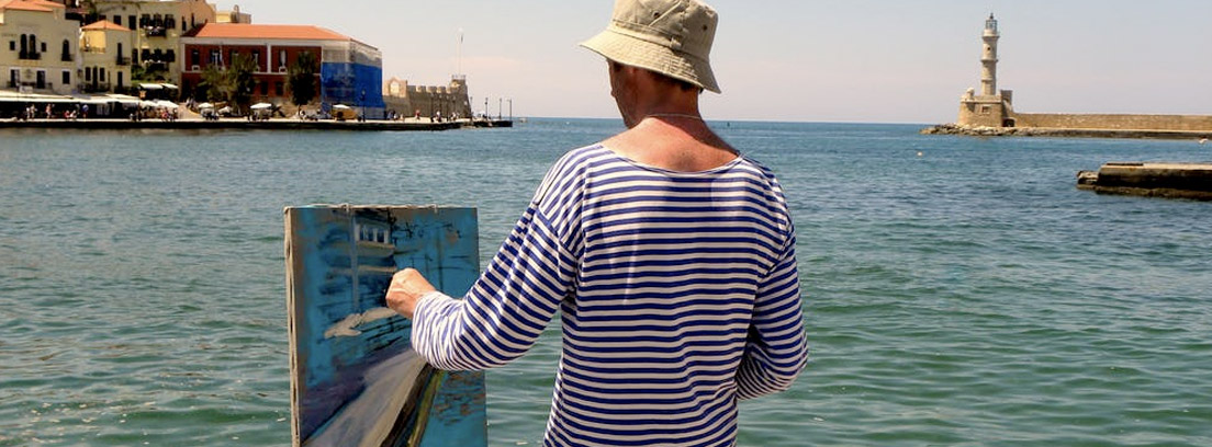 Hombre delante del mar pintando un cuadro al óleo