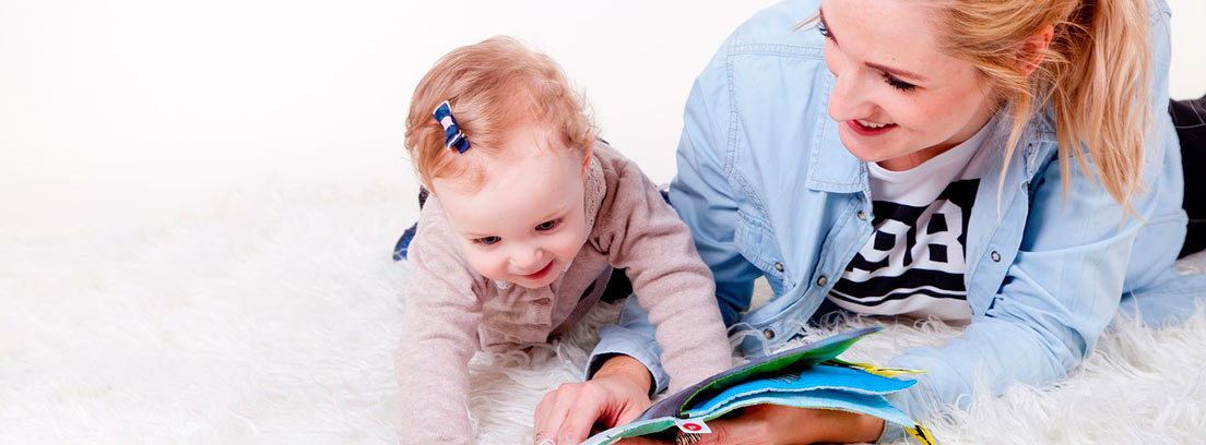 Chica leyendo un cuento a un bebé sonriente
