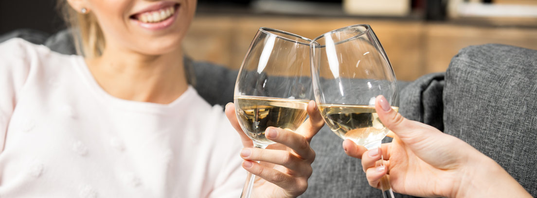 Dos personas brindando con copas de vino moscatel