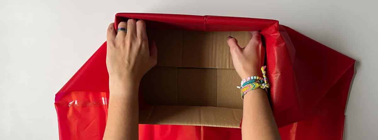 manos decorando caja de cartón
