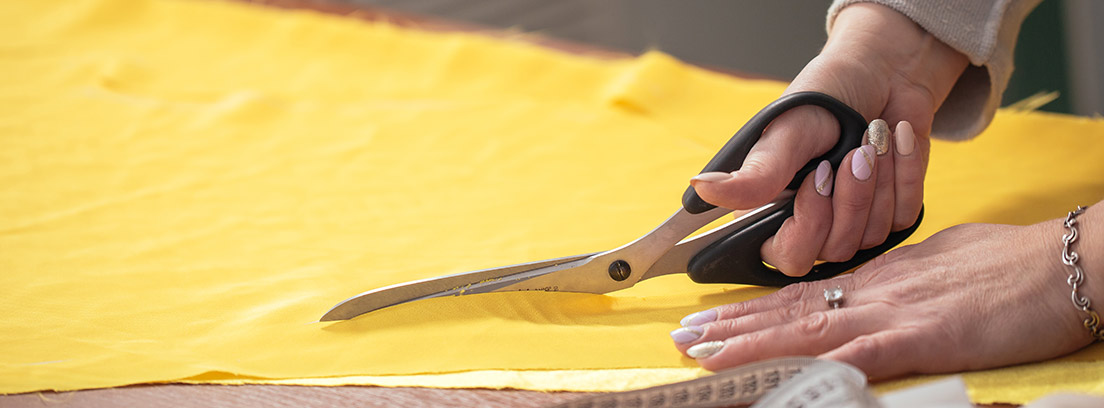 Mujer cortando tela de color amarillo