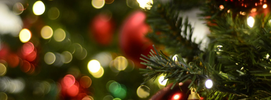 Vista parcial de un árbol de navidad con adornos y luces