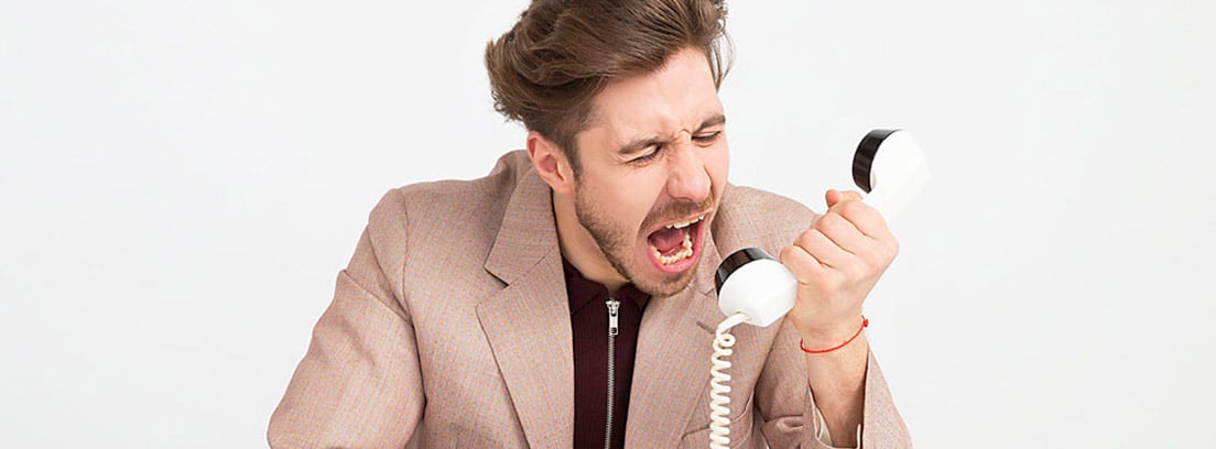 Hombre gritando a un teléfono para dar de baja los suministros