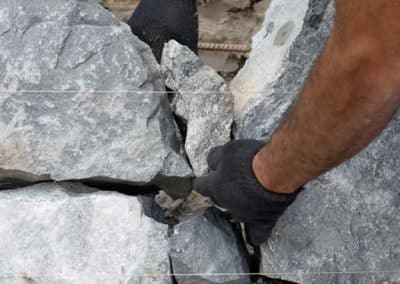 Hombre construyendo una pared de piedra natural