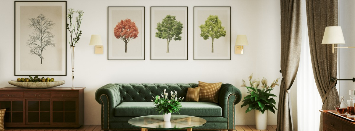 salón con tres cuadros verticales sobre la pared donde está el sofá