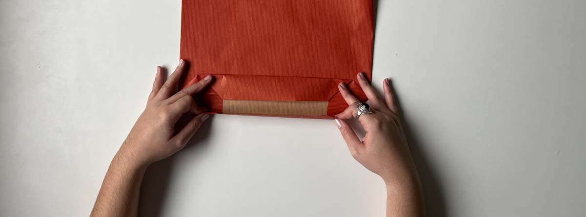 doblez en el papel para hacer la bolsa de regalo