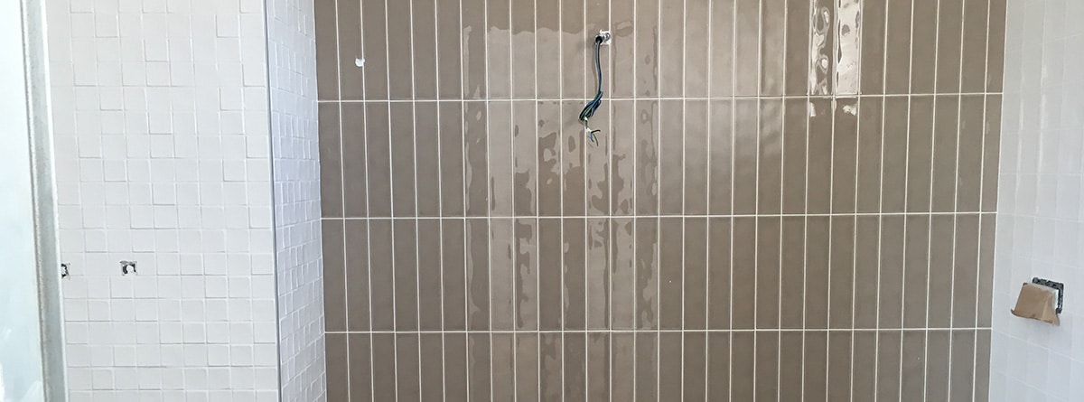pared de un baño alicatada y con azulejos nuevos