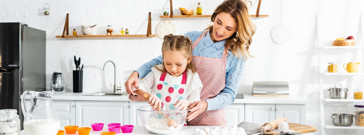 Mujer y niña preparando una receta de repostería