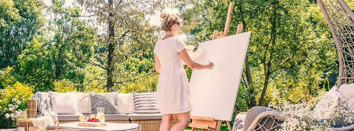 Mujer pintando un cuadro en un patio al aire libre