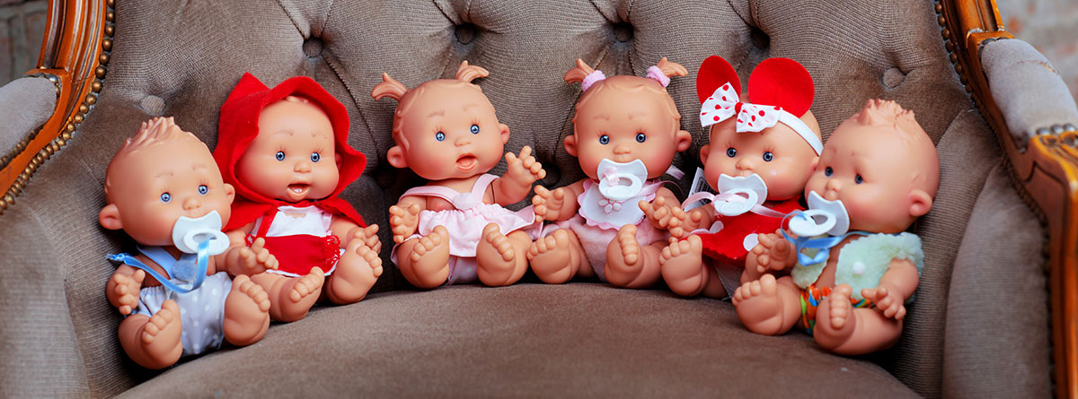 Varias muñecas puestas en un sillón