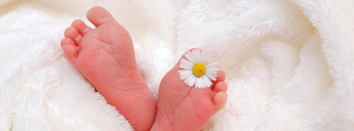 Pies de bebé asomando en una manta blanca