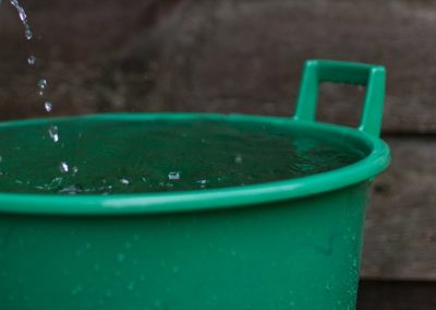 Caldero recogiendo agua de lluvia de un canalón