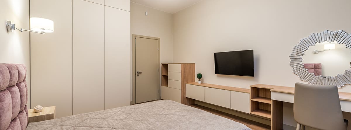 Dormitorio con muebles anclados a la pared y televisor