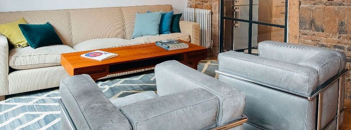 Salón amueblado con sofá, mesa y sillones