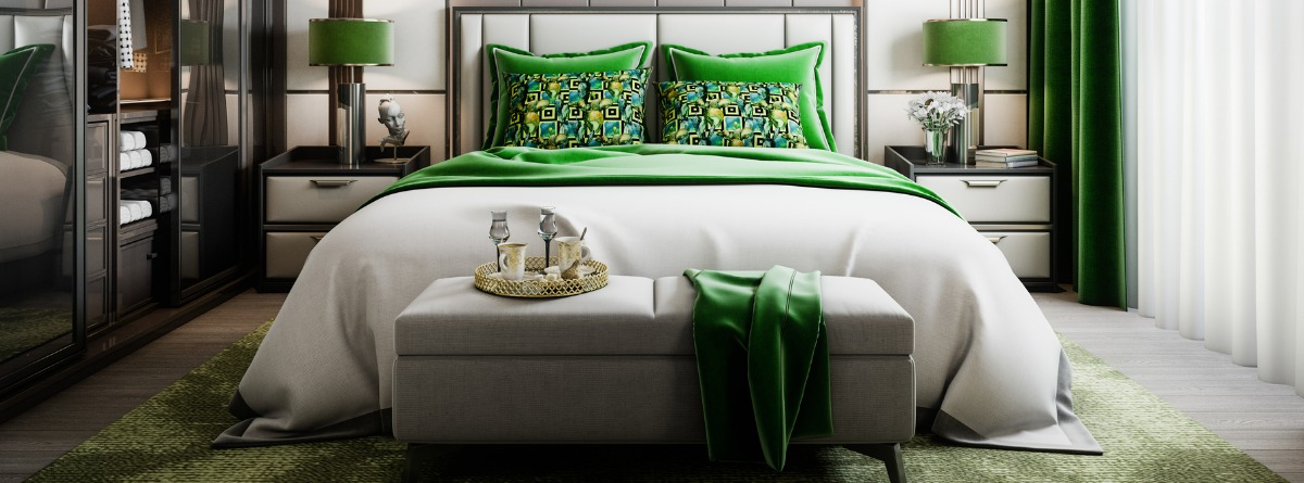 Dormitorio con cama de matrimonio, colores verdes y banco a los pies de la cama