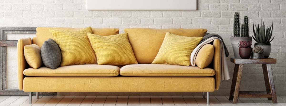 sofá amarillo que destaca sobre pared blanca