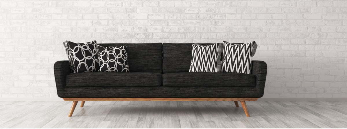 sofá negro que contrasta con pared blanca