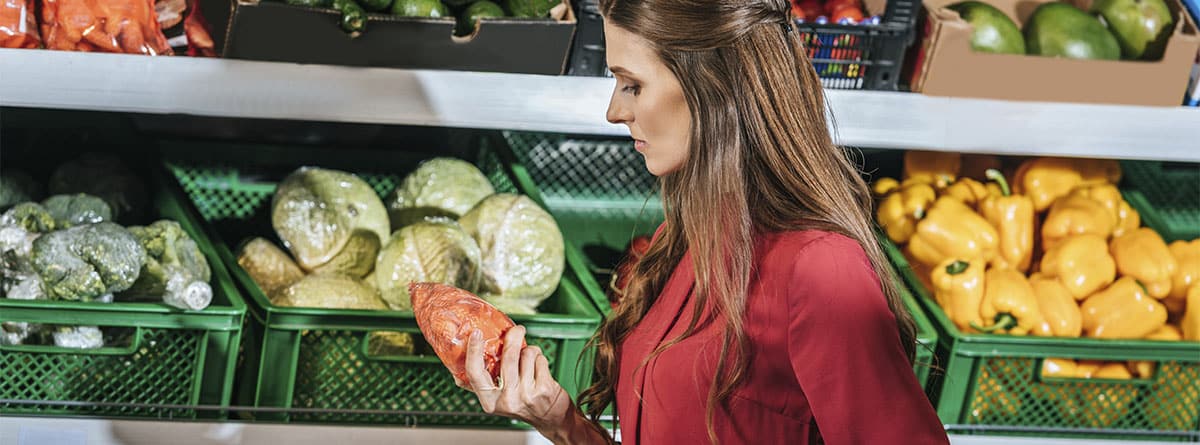 Mujer comparando dos productos en el supermercado