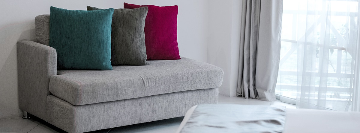 cojines de varios colores sobre un sofá gris