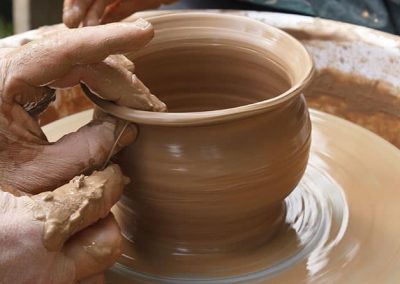 Manos en un torno haciendo cerámica artesanal