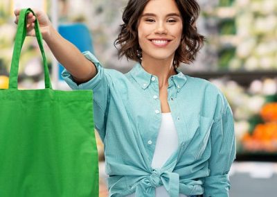 Mujer mostrando una bolsa de rafia en un supermercado