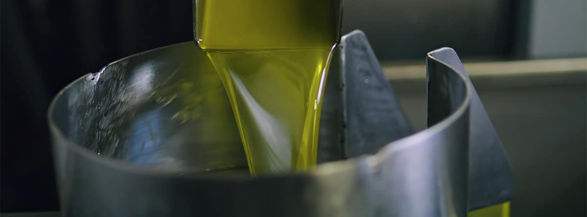 Aceite de oliva que se vierte sobre un recipiente.