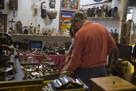 Hombre y mujer miran hacia un mostrador con muchos objetos y elementos