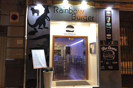 Puertas e cristal con letrero sobre ella y dibujos de hamburguesas en el lateral