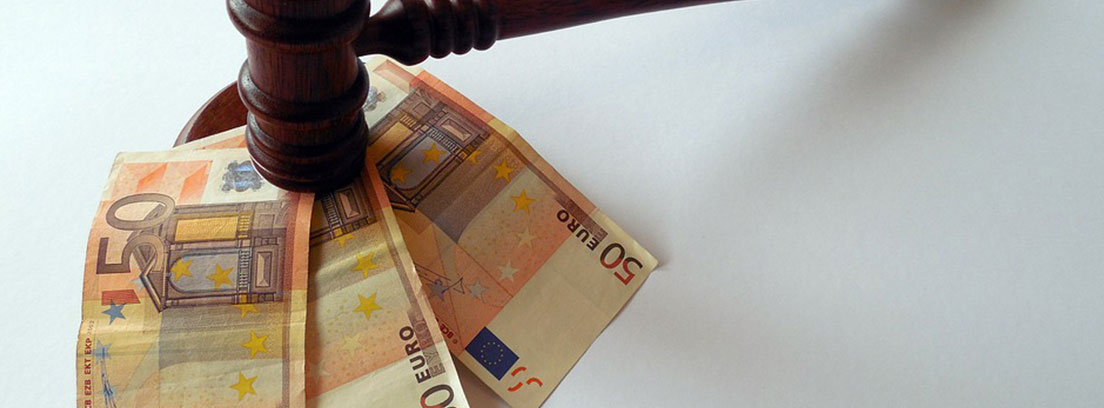 Un mazo de madera golpea tres billetes de 50 euros