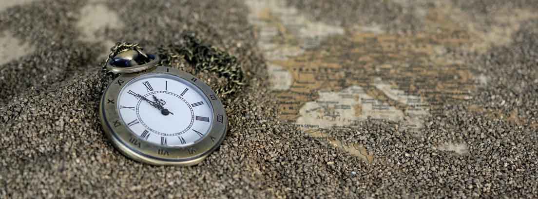Reloj de mano sobre un mapa de Europa cubierto de arena