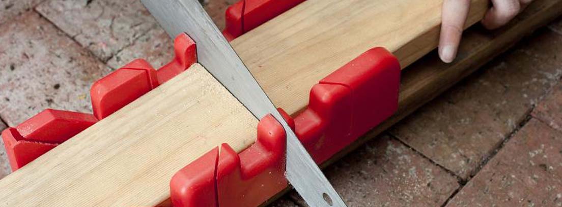 Sierra cortando una madera a inglete para colocar molduras puertas sin clavos
