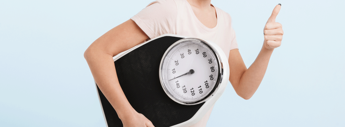Consejos para tu dieta después de Navidad - canalHOGAR mujer feliz sujetando una báscula