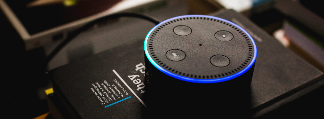 Asistente Amazon Alexa Dot sobre una meda con libros